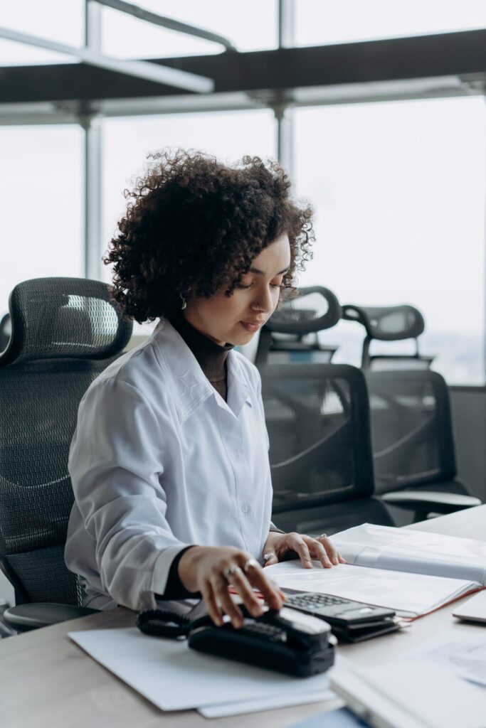 Young Woman Sitting in White Long Sleeve Shirt Working Inside an Office